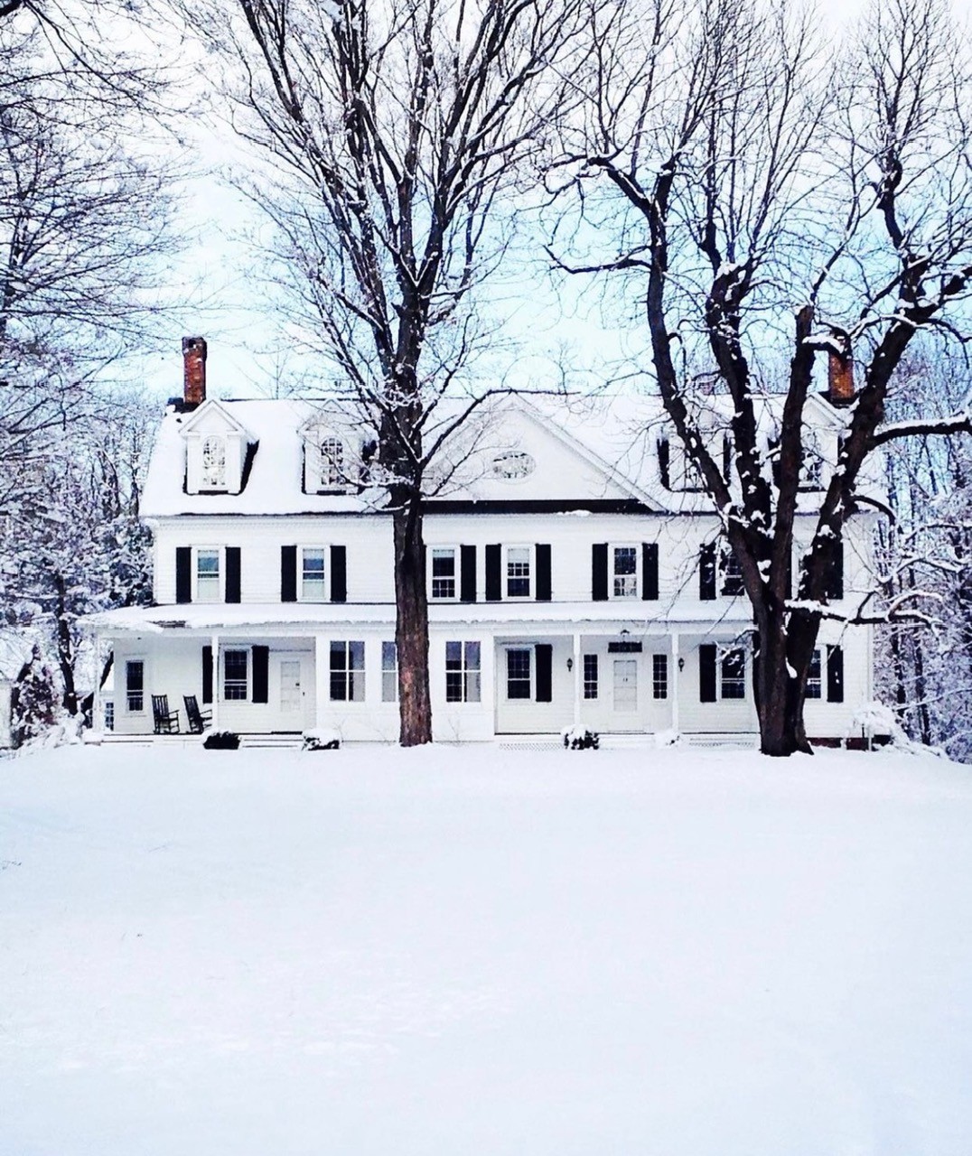 The white farmhouse blanketed in snow
