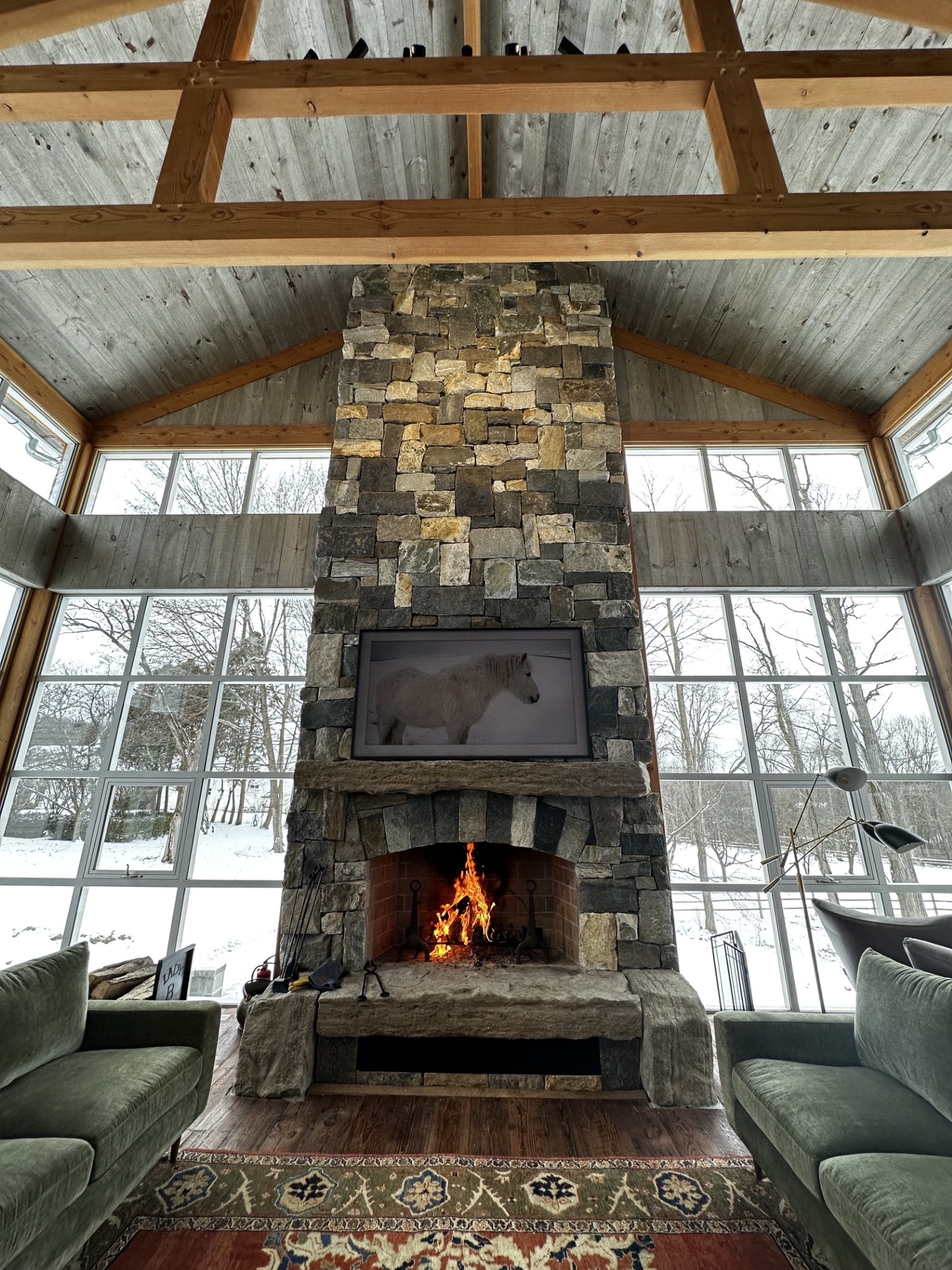 The timber great room with the stone fireplace lit